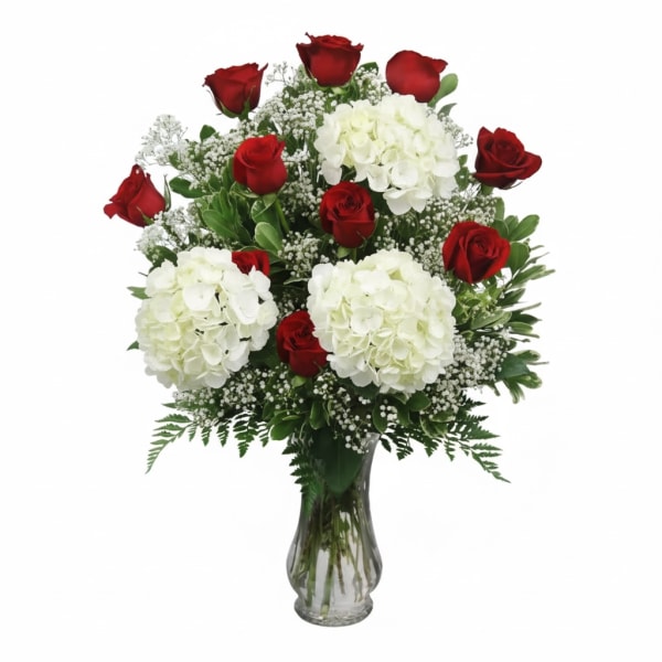 Red roses and white hydrangeas in a clear glass vase
