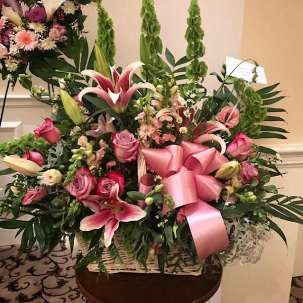 Large pink floral basket with lilies, roses, and a pink ribbon