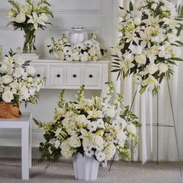 White floral arrangements in vases and a standing spray