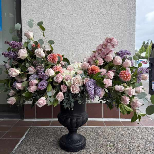 Large pink and lavender floral arrangement in a black urn