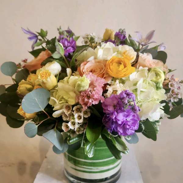 Mixed bouquet of pastel flowers in a striped glass vase