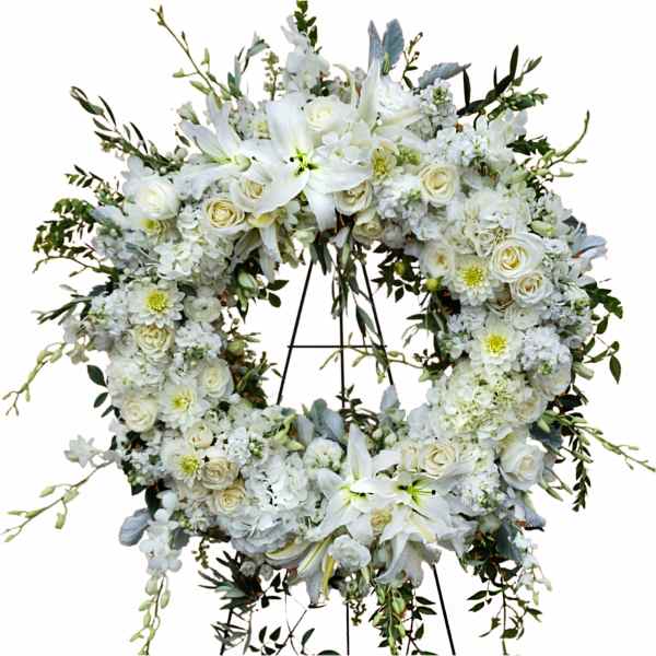 White floral wreath on a stand with roses and lilies