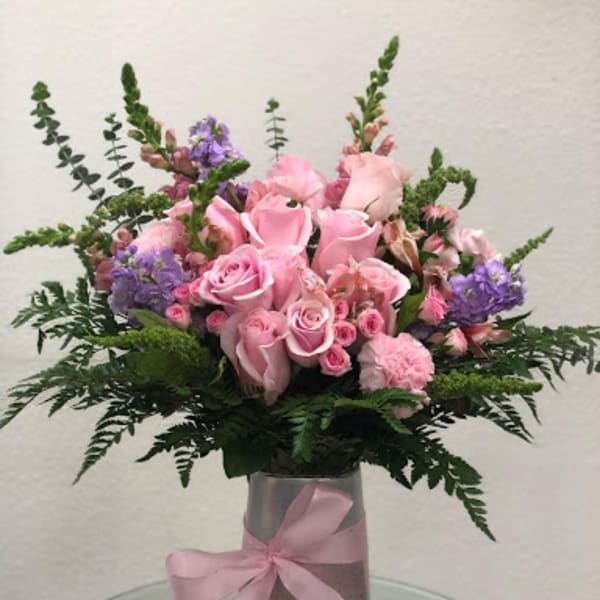 Pink rose bouquet in a silver vase with a pink ribbon