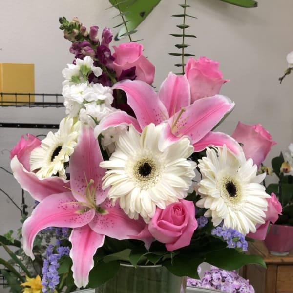 Pink lilies and white gerbera daisies in a glass vase