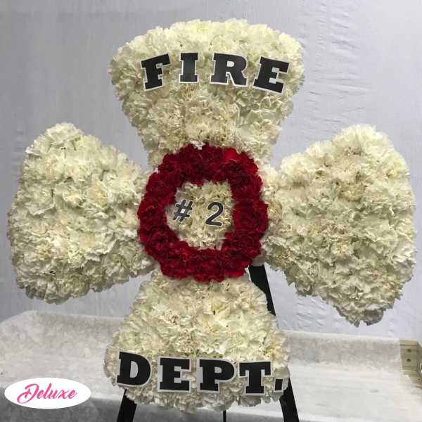 White floral standing display shaped like a fire department emblem with red center