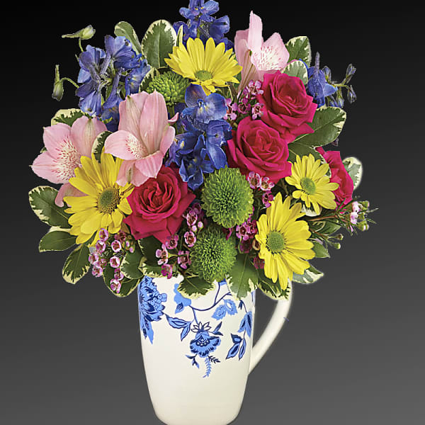 Colorful mixed bouquet in a white floral mug vase