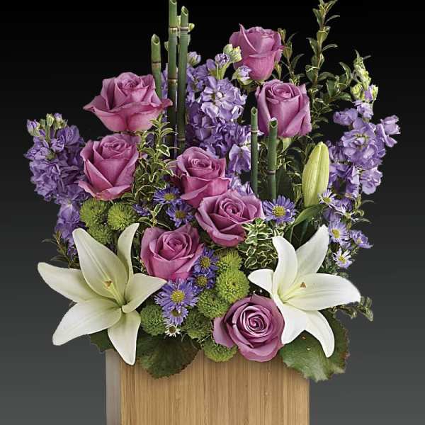 Purple roses and white lilies in a wooden box