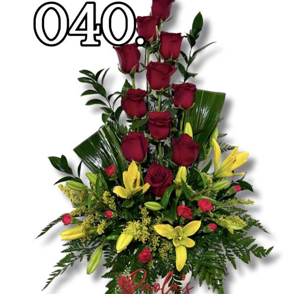 Tall arrangement of red roses and yellow lilies in a white vase