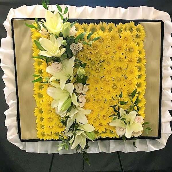 Yellow floral funeral spray with white lilies and roses