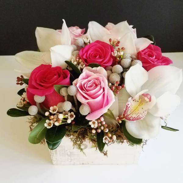 Pink and white roses with white lilies in a rectangular vase