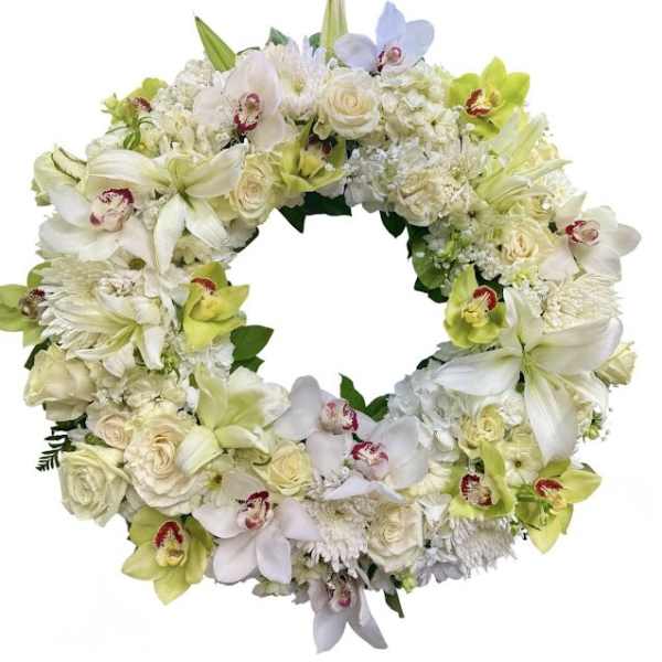 Circular floral wreath of white and pale green blooms with orchids and roses