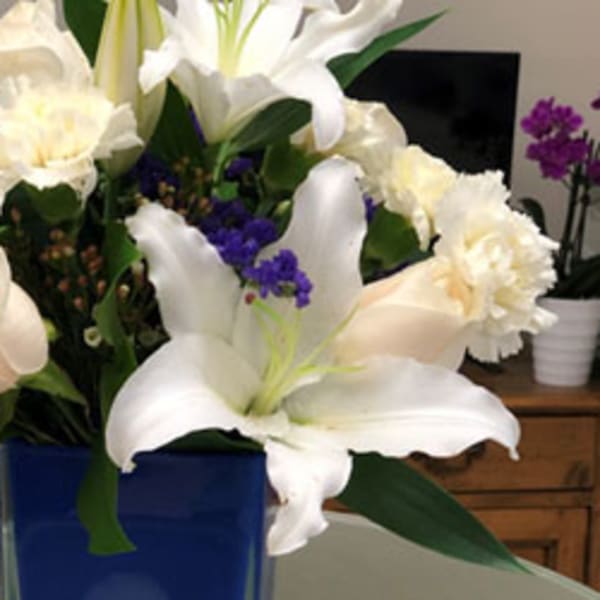 White lilies and pale roses in a blue vase