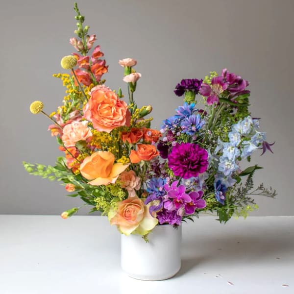 Colorful mixed flower arrangement in a white vase