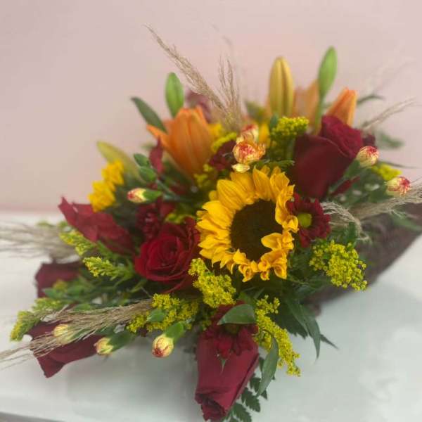 Bouquet of red roses and a yellow sunflower with orange lilies