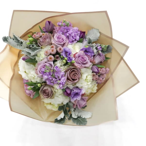 Bouquet of lavender and white flowers wrapped in tan paper