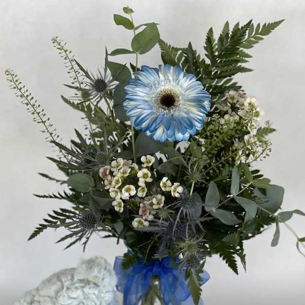 Blue flower bouquet with a teddy bear and ribbon