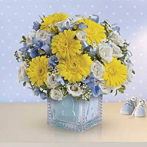 Bouquet of yellow daisies and white roses in a blue glass vase
