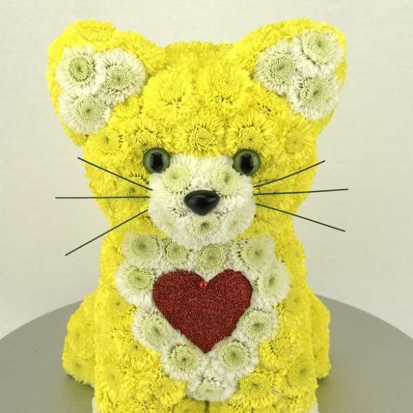 Yellow and white flower arrangement shaped like a teddy bear with a red heart