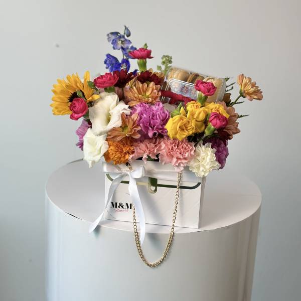 Colorful mixed flower arrangement in a white gift box with a ribbon