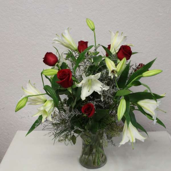 Red roses and white lilies in a clear glass vase
