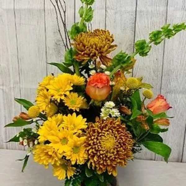 Yellow and orange chrysanthemum arrangement with green accents