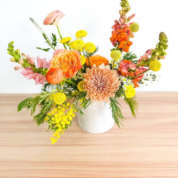 Colorful mixed flower arrangement in a white vase