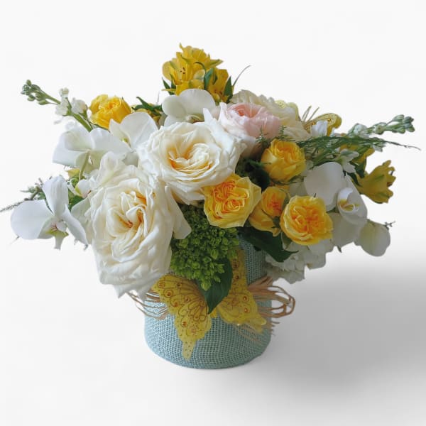Bouquet of white and yellow roses in a blue textured vase