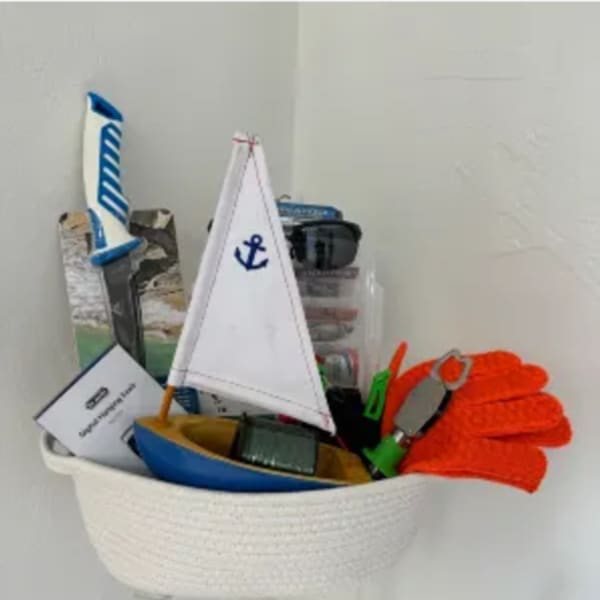 Basket of toy sailboats and nautical accessories