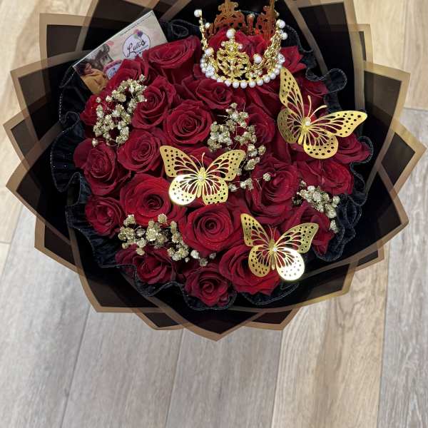 Bouquet of red roses with gold butterfly decorations and a jeweled crown