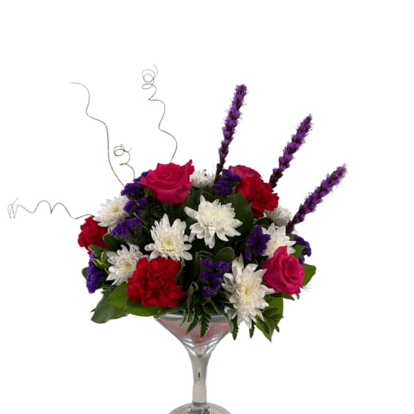 Mixed bouquet in a martini glass with pink roses, white daisies, and red carnations