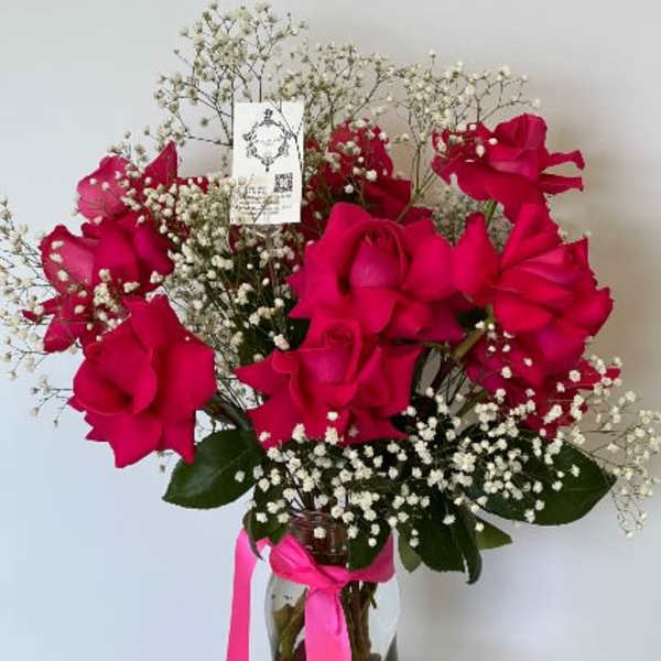 Bouquet of hot pink roses with baby's breath in a glass vase