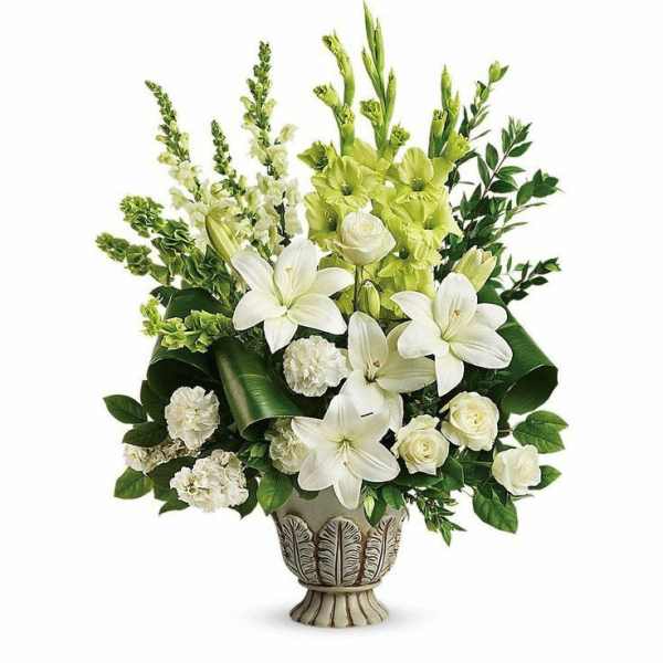 White and green floral arrangement in a decorative urn vase