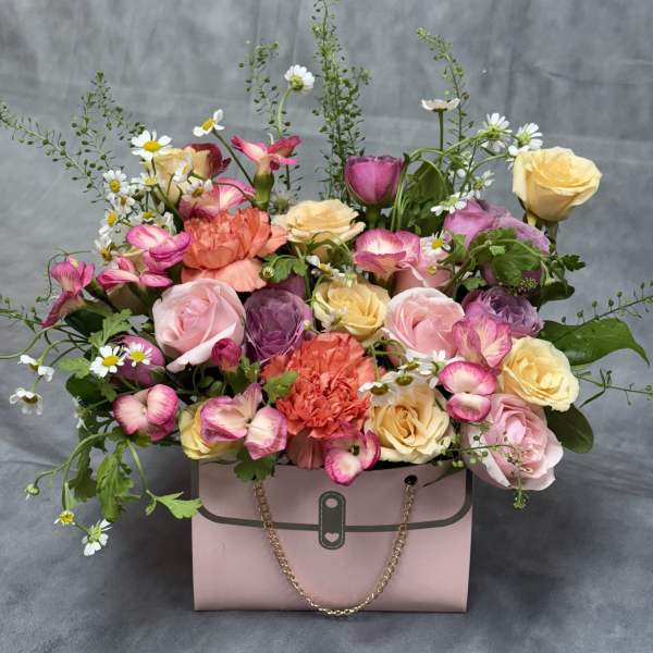 Pink gift box filled with roses, carnations, and daisies