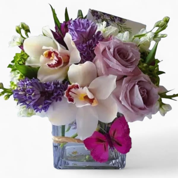 Bouquet of lavender roses, white orchids, and purple flowers in a glass vase