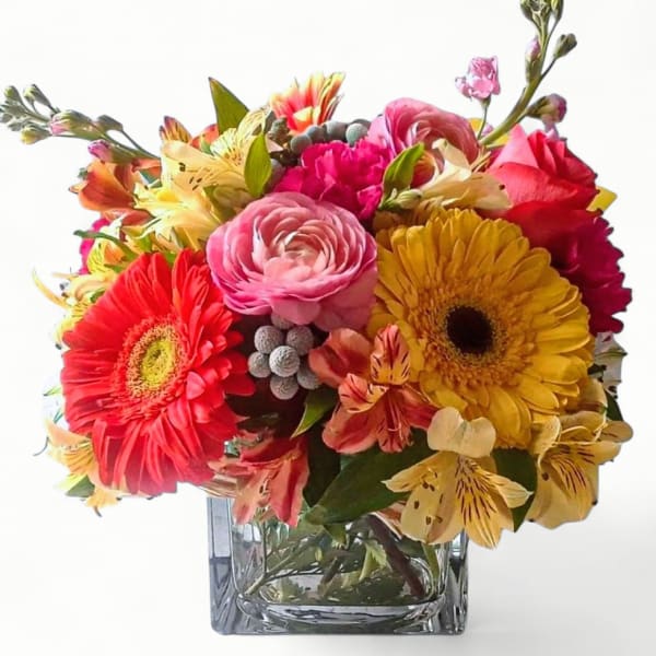 Colorful mixed bouquet in a square glass vase