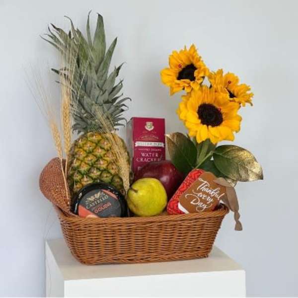Gift basket with sunflowers, pineapple, fruit, crackers, and cheese