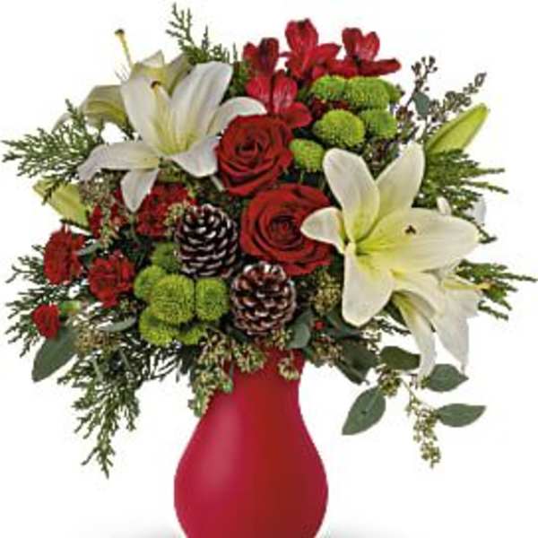 Red roses and white lilies in a red vase with pinecones