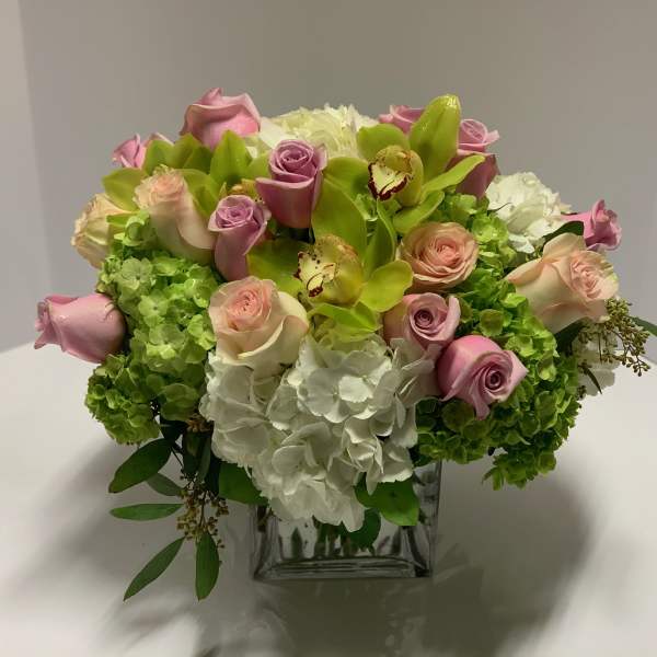 Pink roses and white hydrangeas in a clear square vase