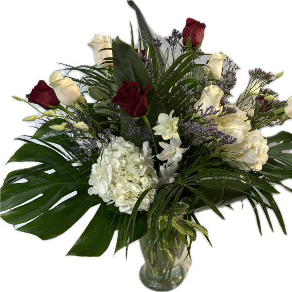 Bouquet of red and white roses with white hydrangeas in a glass vase