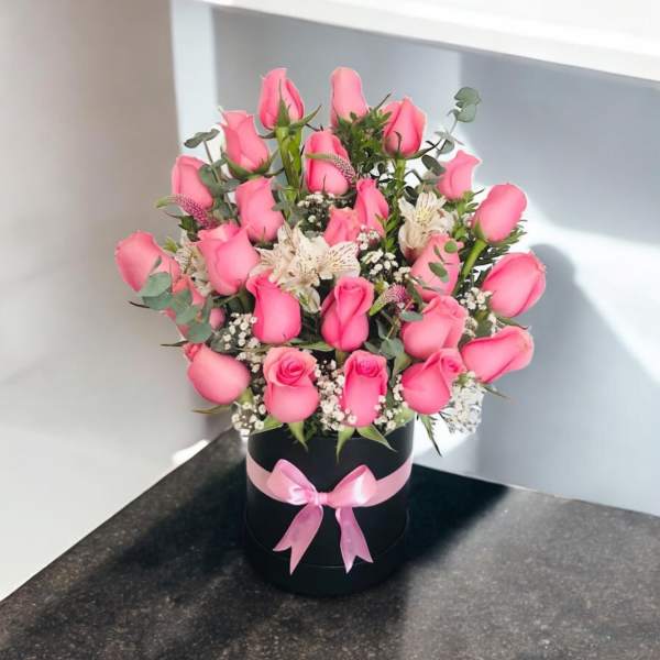Pink rose bouquet in a black hat box with a pink ribbon