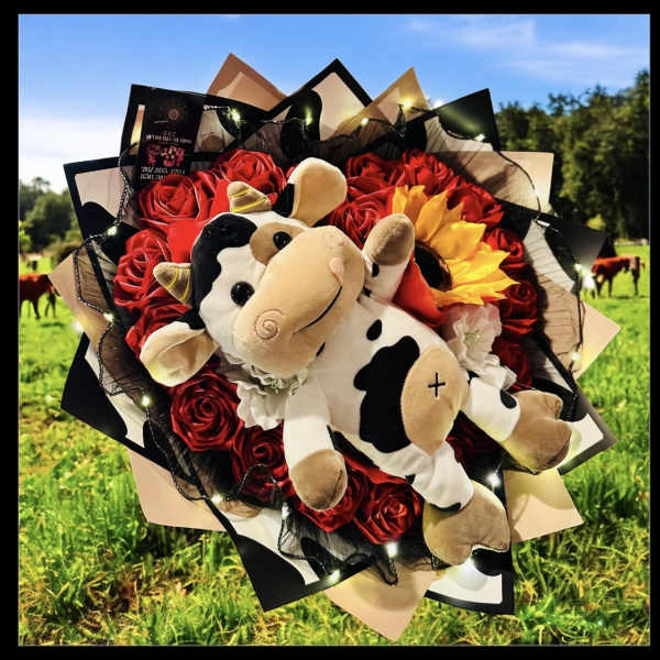 Bouquet of red roses with a plush cow in the center