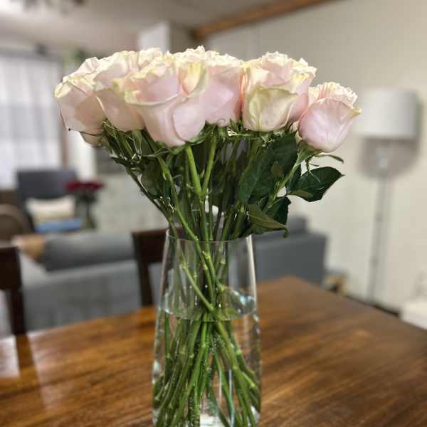 Bouquet of pale pink roses in a clear glass vase