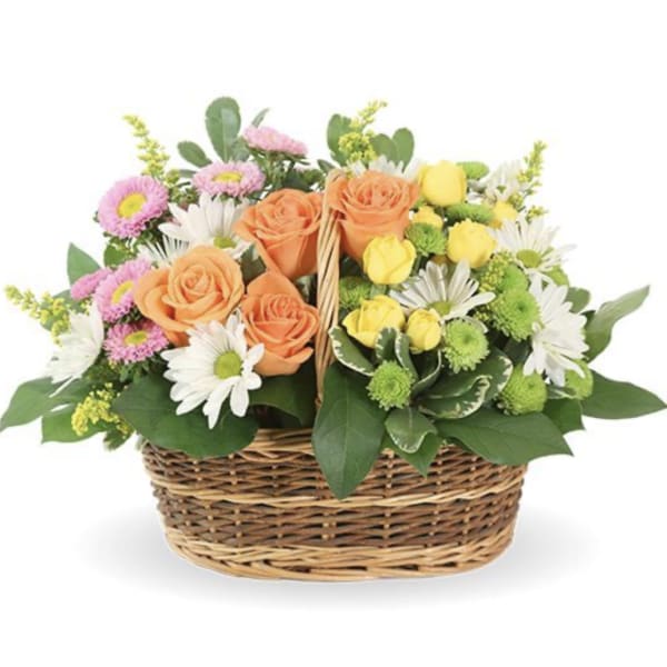 Mixed bouquet of roses, daisies, and mums in a wicker basket