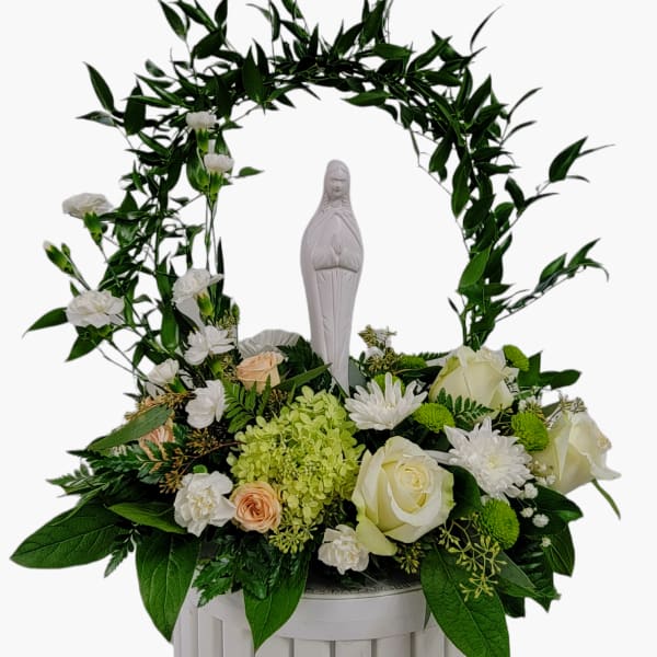 White religious statue framed by an arch of greenery and white flowers in a white container