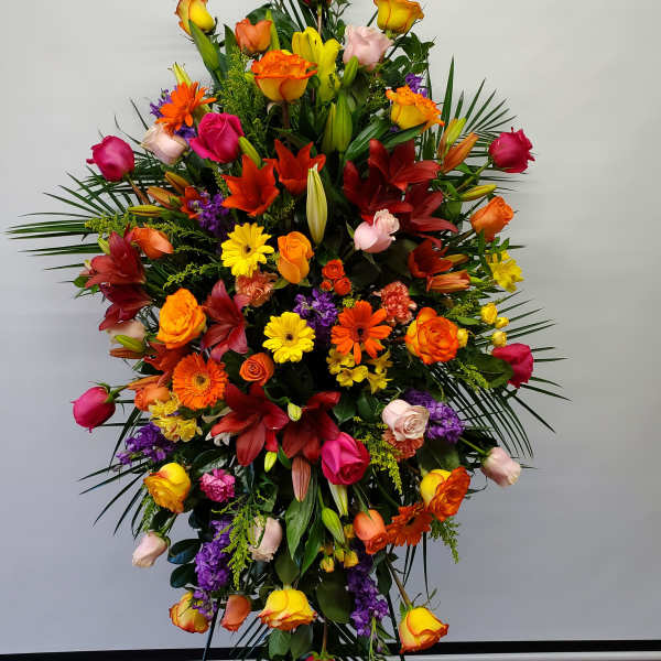 Tall standing spray of mixed roses, lilies, and gerbera daisies