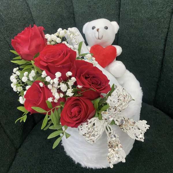 Red roses with baby's breath and a white teddy bear holding a heart