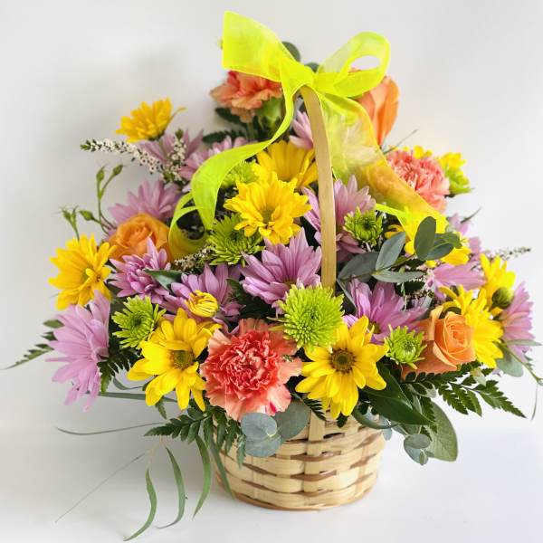 Basket of mixed flowers with a neon ribbon bow