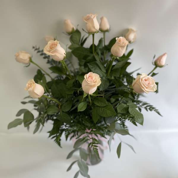 Bouquet of pale peach roses with greenery in a vase