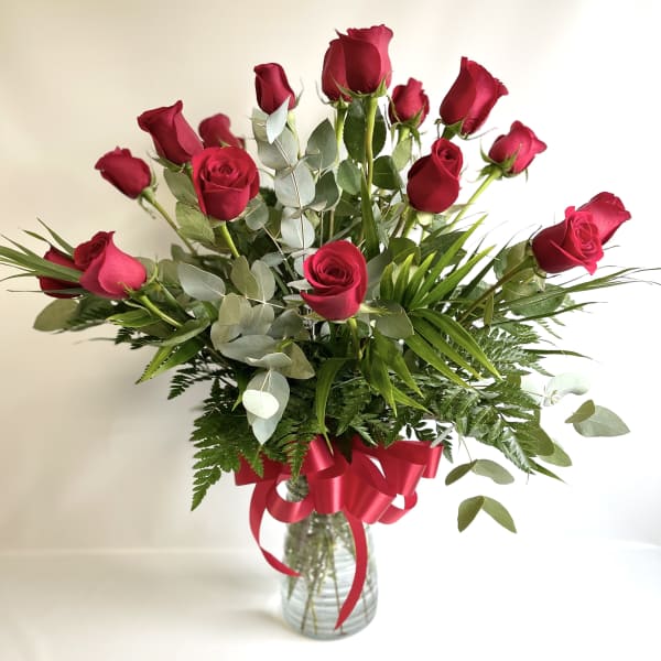 Bouquet of red roses in a glass vase with a red ribbon