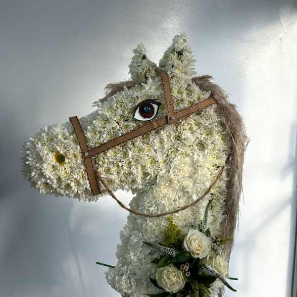Horse-shaped floral standing display with white flowers and a small bouquet